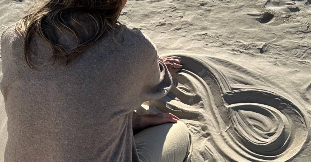 Hände zeichnen eine Lemniskate in den Sand als Symbol für innere Unruhe verstehen und innere Ruhe im Körper